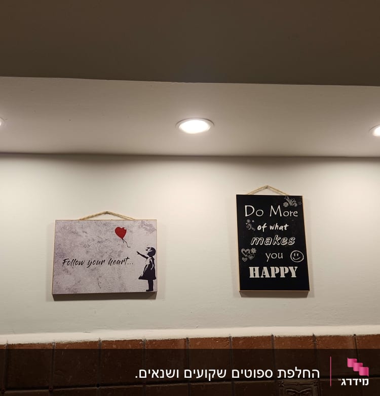 שלושה פנסי תקרה מוארים על קיר לבן